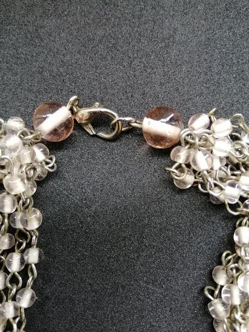 Collier à 9 brins tressés en métal argenté et perles de verre rose transparent