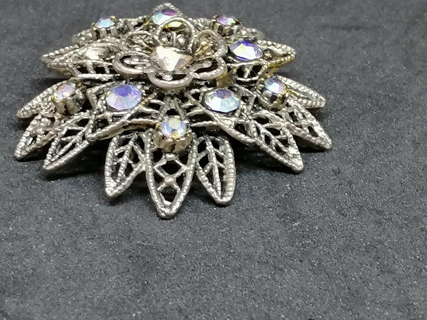 Broche fleur en métal argenté avec des brillants