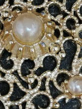 Charger l&#39;image dans la galerie, Collier en métal doré avec pendentif avec de perles et derrière un miroir
