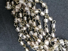 Charger l&#39;image dans la galerie, Collier à 9 brins tressés en métal argenté et perles de verre rose transparent
