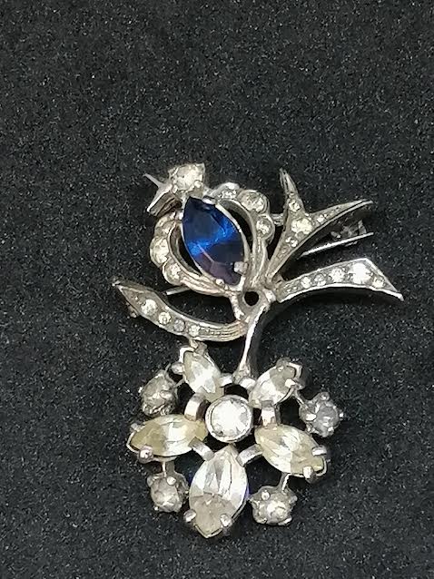 Broche en métal argenté avec brillants transparents et un bleu
