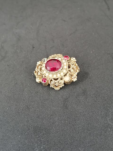 Broche en métal doré avec des perles en verre imitation rubis et petites perles en nacre