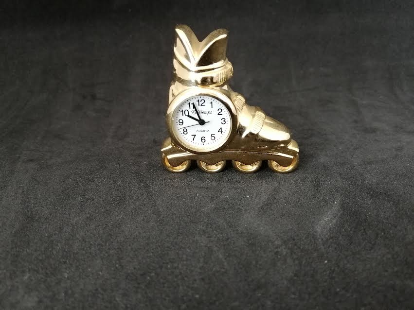Horloge quartz en forme de patin à roulettés en métal doré