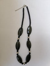 Charger l&#39;image dans la galerie, Collier noir avec des décorations dorées, perles de verre noires et argentées
