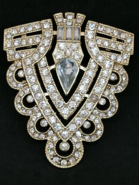 Pendentif en métal doré et brillant, avec deux boucles
