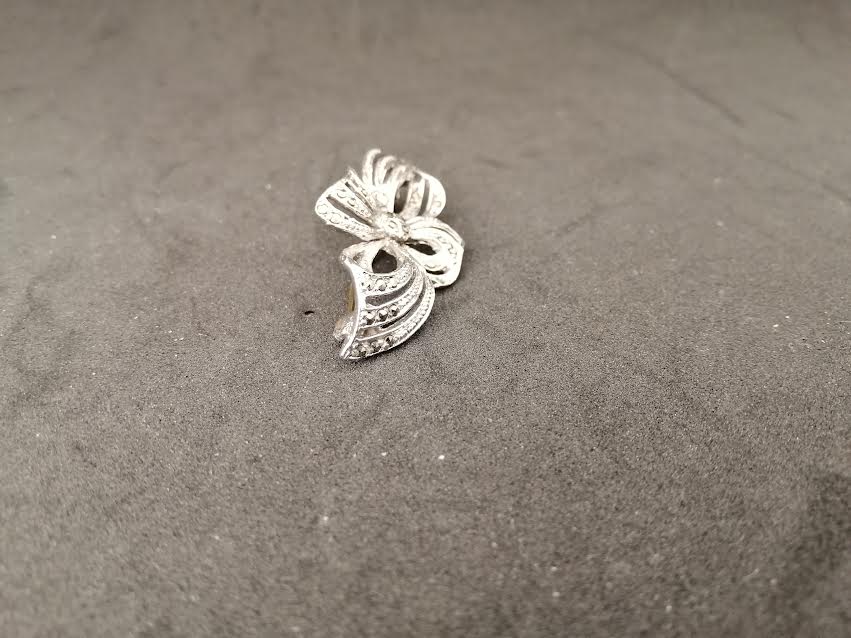 Broche en métal argenté avec des petits brillants