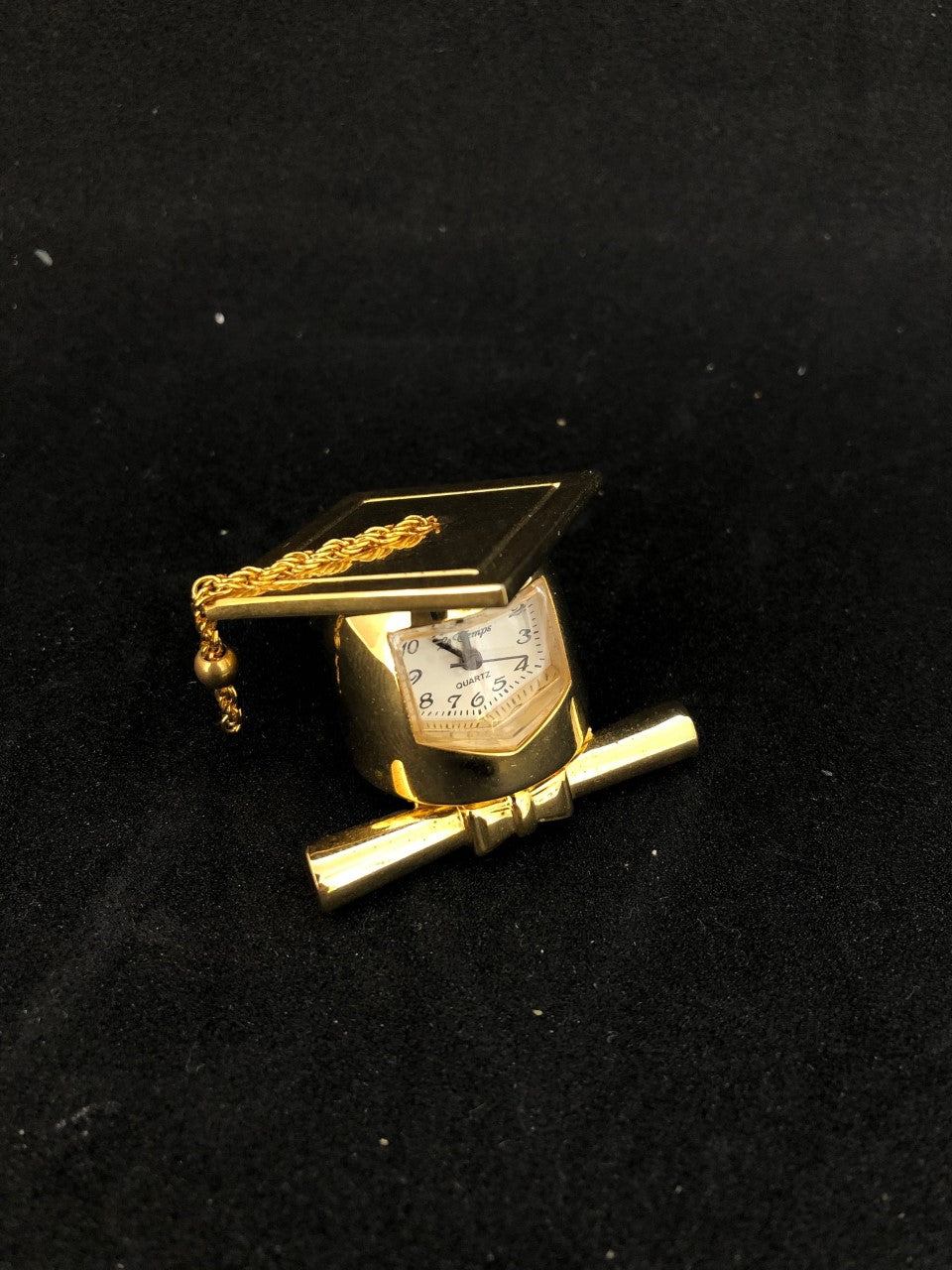 Petite horloge dorée en forme de mortier de diplôme